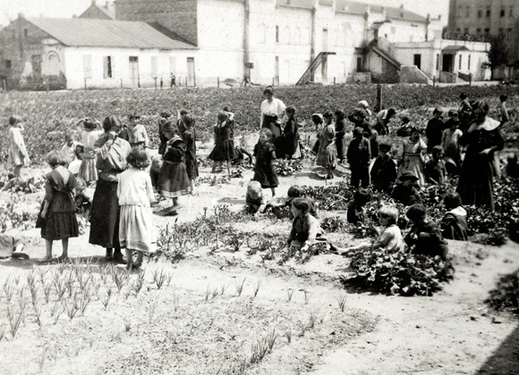 JDC also funded agricultural programs for school children. Students in boarding schools and orphan asylums learned to grow vegetable gardens under the guidance of trained instructors, provided by ORT. These children tended the garden at Mendele's Kindergarten and Community School at the Bialystok Jewish Youth Union. Poland, c. 1918, <em>NY_01436</em>.
