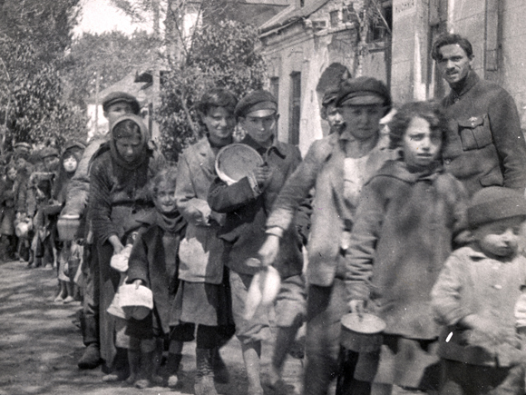 A daily meal at JDC-funded food centers kept many Jews from starving. These children waited in a soup line in Lvov. Poland (now Ukraine), c. 1919, <em>NY_01951</em>.
