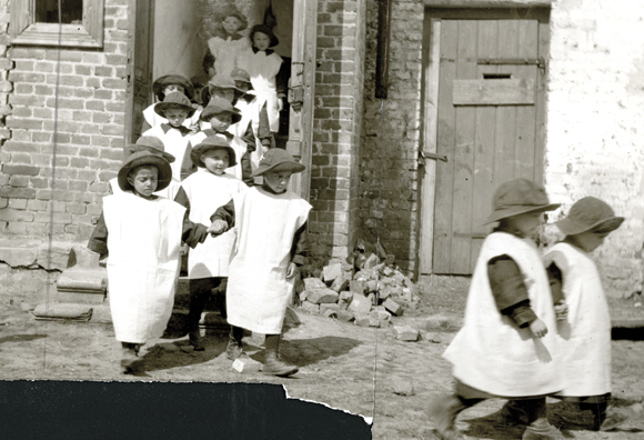 JDC provided $500,000 in clothing to children in Poland through ARA's European Children's Fund. Shoes, hats, and stockings were furnished to these orphans in Grodno, but other items were still in short supply. To bridge the gap, JDC workers converted the sacks which had carried flour for the poor. Poland (now Belarus), c. 1920, <em>International News Photos, NY_01952</em>. 
