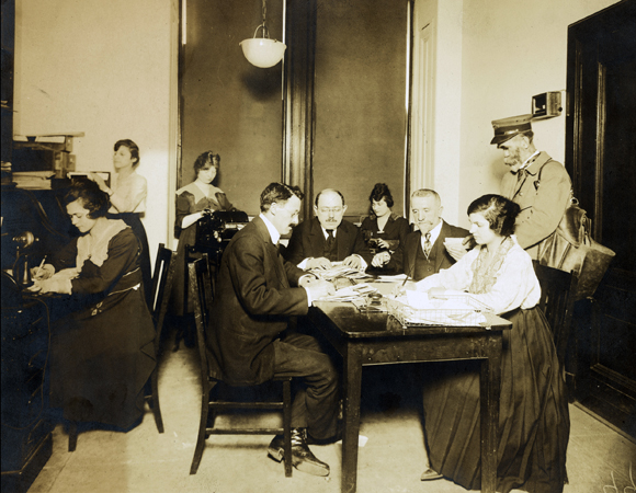 Initially, each participating organization of the Joint Distribution Committee independently raised funds, which were then pooled. At the Central Relief Committee, Financial Secretary Morris Engelman (center), Treasurer Harry Fischel (right), and staff received contributions from Orthodox congregation members through a Passover campaign. Many contributors were immigrants with ties to communities abroad. Even small contributions often involved self-sacrifice by the donors. U.S., c. 1918, <em>NY_03487</em>.
