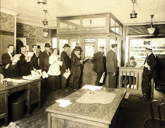 Wartime conditions made it impossible for American Jews to send money to relatives overseas. JDC opened a Transmission Bureau on January 1, 1915, with additional branches later in Baltimore, Boston, Chicago, Cincinnati, Cleveland, and San Francisco. At the Educational Alliance, a haven for Jewish immigrants on New York's Lower East Side, a branch operated only on Saturday evenings. People lined up to make deposits, generally $5 or $10. By August 1918, the Bureau had handled close to $608,000 in remittances. U.S., c. 1918, <em>NY_03488</em>.

