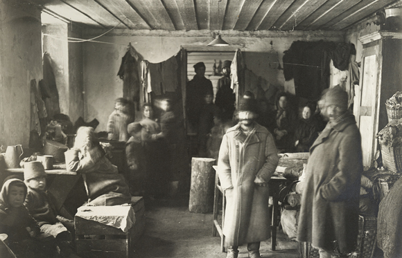 In early 1915, the Russian Government had forcibly expelled Jews with only twelve hours notice from Lithuania and parts of Latvia and Romania. Old men, sick women, and young children alike had to leave with only the possessions they could carry and move to the Russian interior. Refugees could not go home until hostilities ended in 1920. These returning refugees shared a one-room shelter in Jaunjelgava. Latvia, c. 1921, <em>NY_08663</em>.
