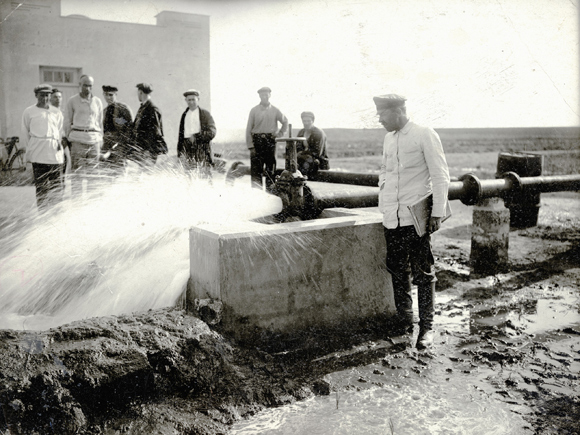 Hand-made wells were labor intensive to dig, and couldnt provide sufficient irrigation. Agro-Joint drilled for water and built artesian wells with motors to pump it out continuously. Irrigation dramatically reduced the acreage needed to sustain a family from forty-five acres (dry land needed) to around six. While looking for water in the Saki District, Agro-Joint engineers discovered a previously unknown underground stream that opened up large, new territories for settlement. The Artesian well at this pumping station was one of 47 built to pipe this new source of water into distant fields. Crimea, 1934, <em>NY_00691</em>.