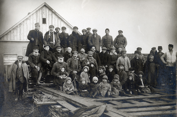 By pooling their efforts, newly adjusting colonists increased their chances of success. Settlers, aged 2 to 70 pose with their newly delivered wood at Novy Put (New Path) colony in the Krivoy Rog District. Ukraine, c. 1925, <em> NY_00777</em>.