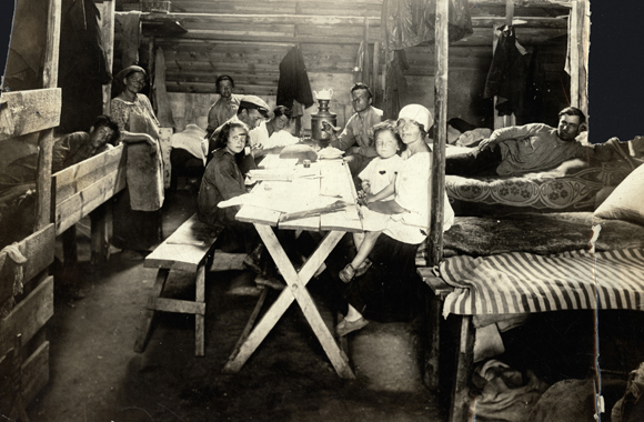 Settlers first lived in dilapidated houses, barns, or dugouts while they constructed permanent homes. These colonists began their new lives in crude temporary barracks, where the only amenity was the samovar they brought with them. Crimea, Russia, c. 1926,  <em>NY_00847</em>.