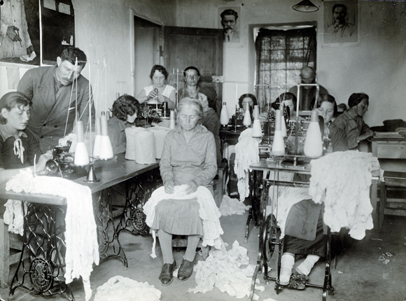 Winter made most farming activities impossible. Colonists turned to light industry indoors like knitting, sewing, and glass blowing. A knitting cooperative in one of the colonies. Crimea, c. 1930, <em>NY_42811 (from YIVO)</em>.