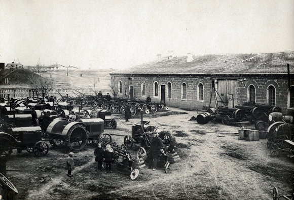 The centrally located district of Jankoy, a site for tractor repair workshops, became Agro-Joint's main base for farm equipment in 1929. Its technicians watched over the smooth functioning of some 1,000 tractors, 100 combines, 500 motorized wells, and 100 irrigation pumps in the colonies. Jankoy shops eventually manufactured machine parts, as well as wooden doors and windows, for colony buildings. Thousands trained there, to increase the work force in these skills. Courses were broadened to include grape cultivation, cheese-making, and winter home industries. By 1937, the plant employed 664 people. Crimea, 1929, <em>A. Buler, NY_42873 (from YIVO)</em>.