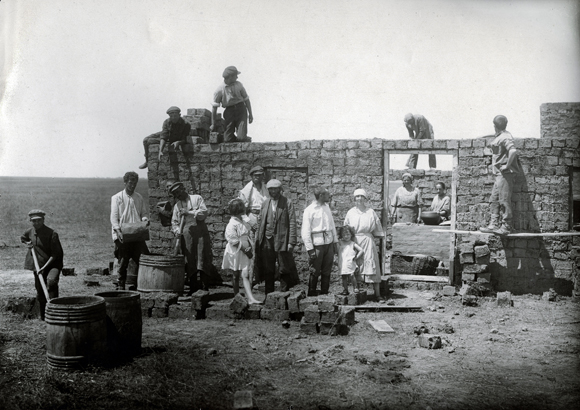 The colonies were chiefly built from the material close at hand. Mud churned with bare feet, then kneaded with straw, was molded into bricks for the Ukrainian colonies. Those in Crimea were made chiefly from the soft, porous sea shell-studded stones that littered the ground. At Oif Lebung (Rebirth) in the Kolay District, as in most colonies, construction was done communally. Ukraine, 1920s, <em>NY_43328 (from YIVO)</em>.