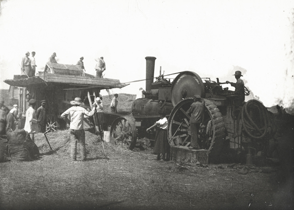 Agro-Joint introduced a small fleet of modern tractors right from the start and continued to bring in mechanized equipment. This enabled colonists to complete farm work faster, maximize crop yield, and reduce the hard labor involved. At Novo-Poltavka, colonists harvested, threshed, and winnowed their grain with the significant help of a motorized combine. Ukraine, c. 1929, <em>NY_44540 (from YIVO)</em>.