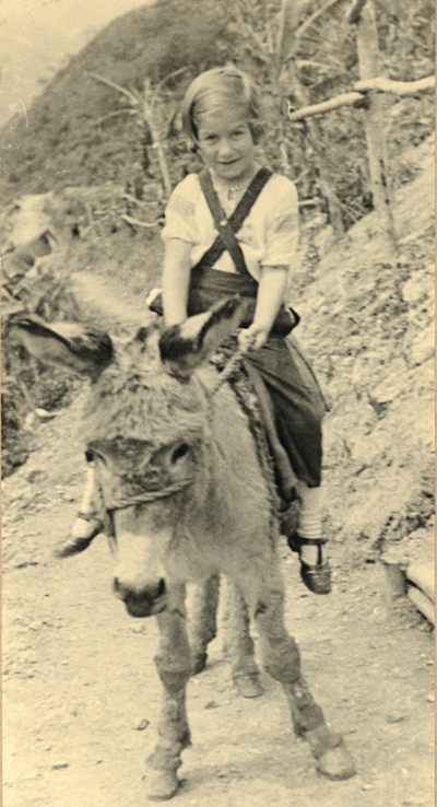 A young girl rides a burro in the Buena Tierra colony. Bolivia, 1941